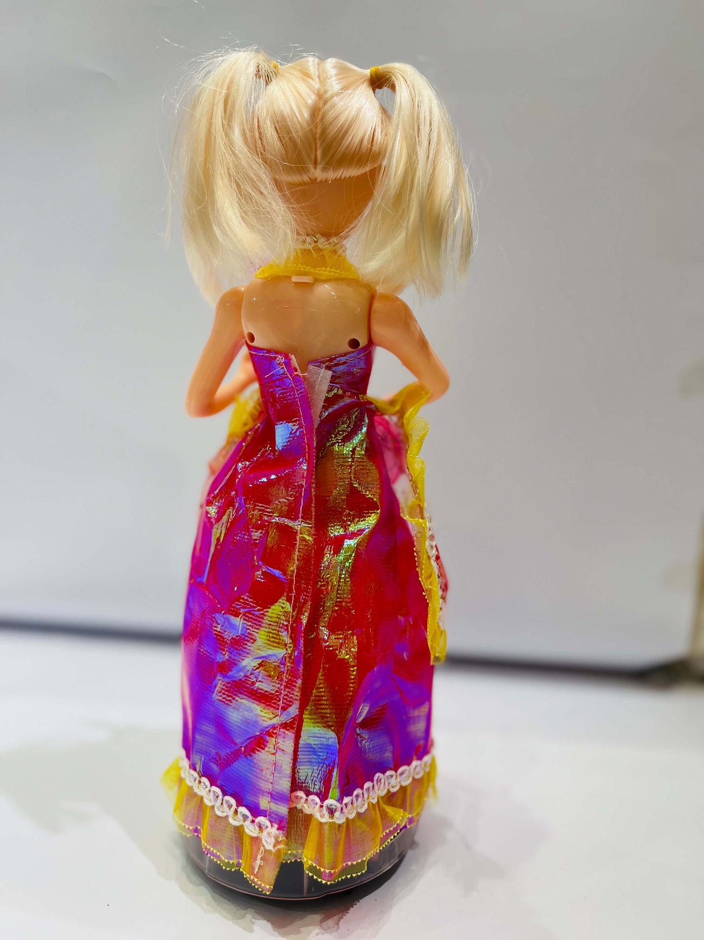 Doll with a colorful dress on a plain background