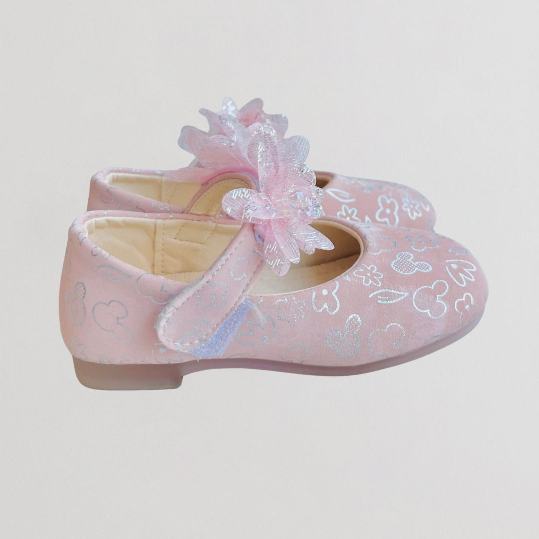 Pink children's shoes with floral design on a light gray background