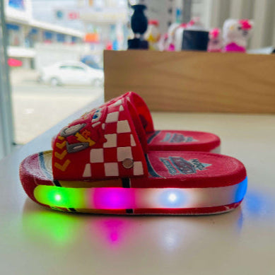 Red checkered slide sandals with colorful LED lights on a white surface.
