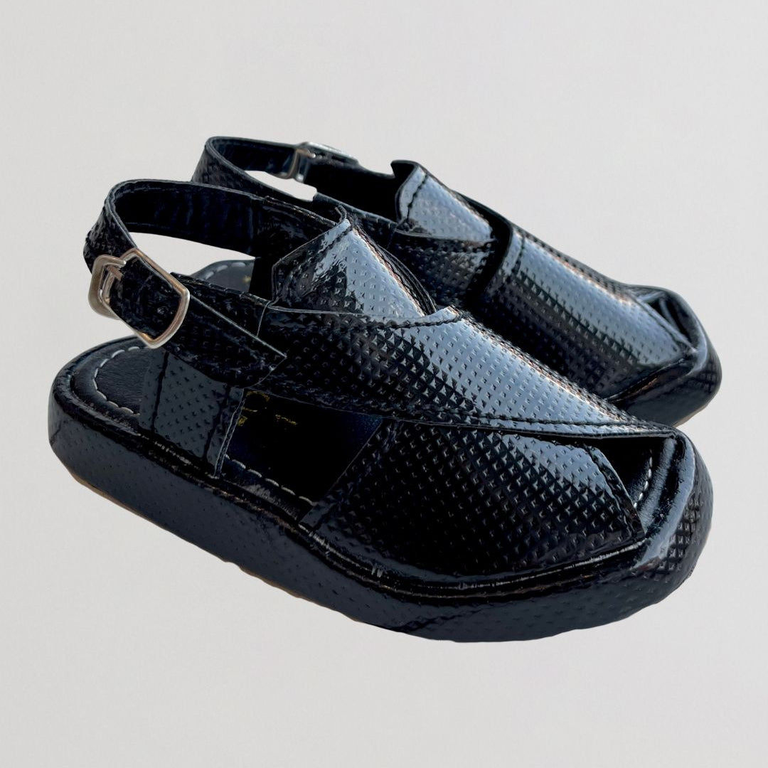 Pair of black sandals with a buckle on a light gray background