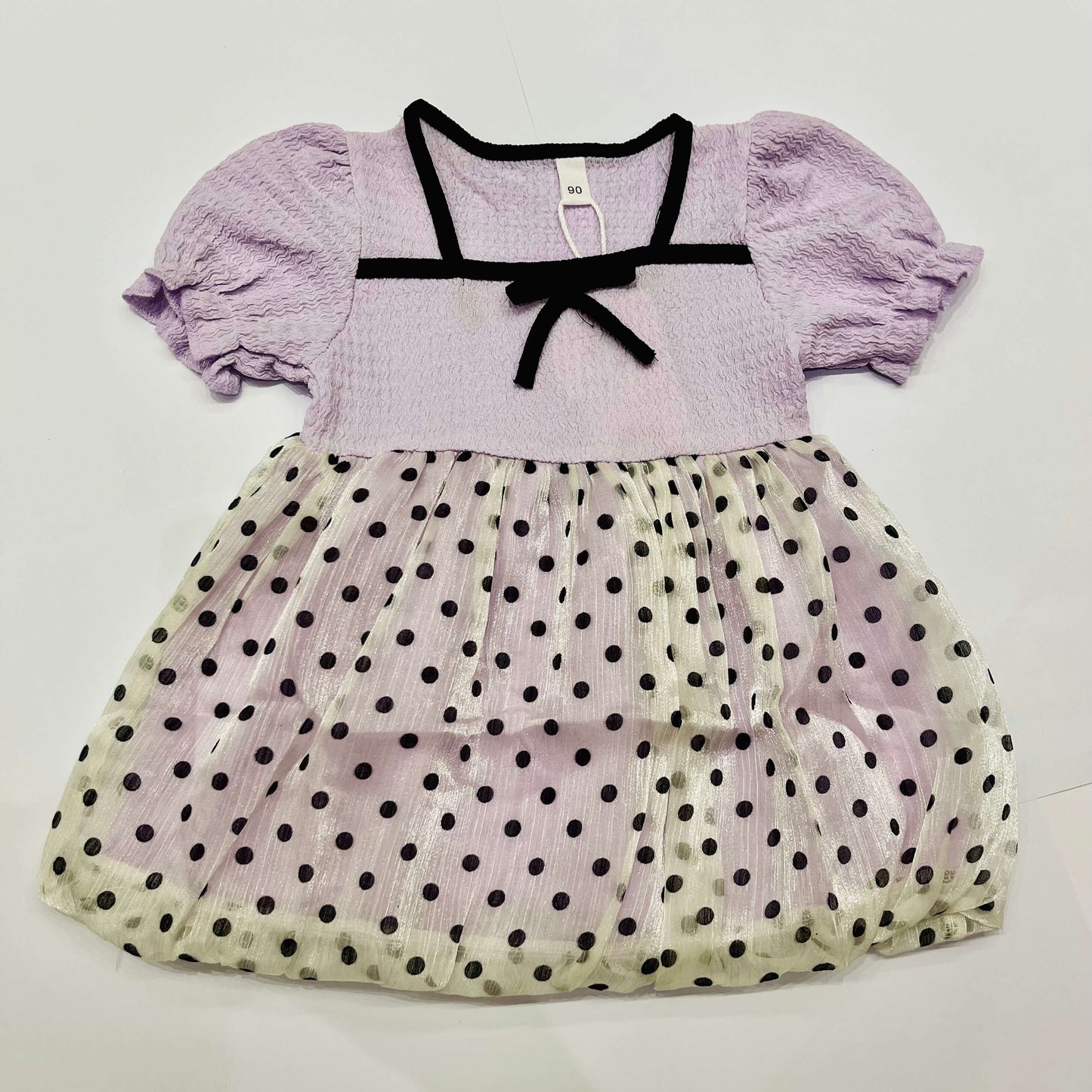 Lavender dress with black polka dots on a white background