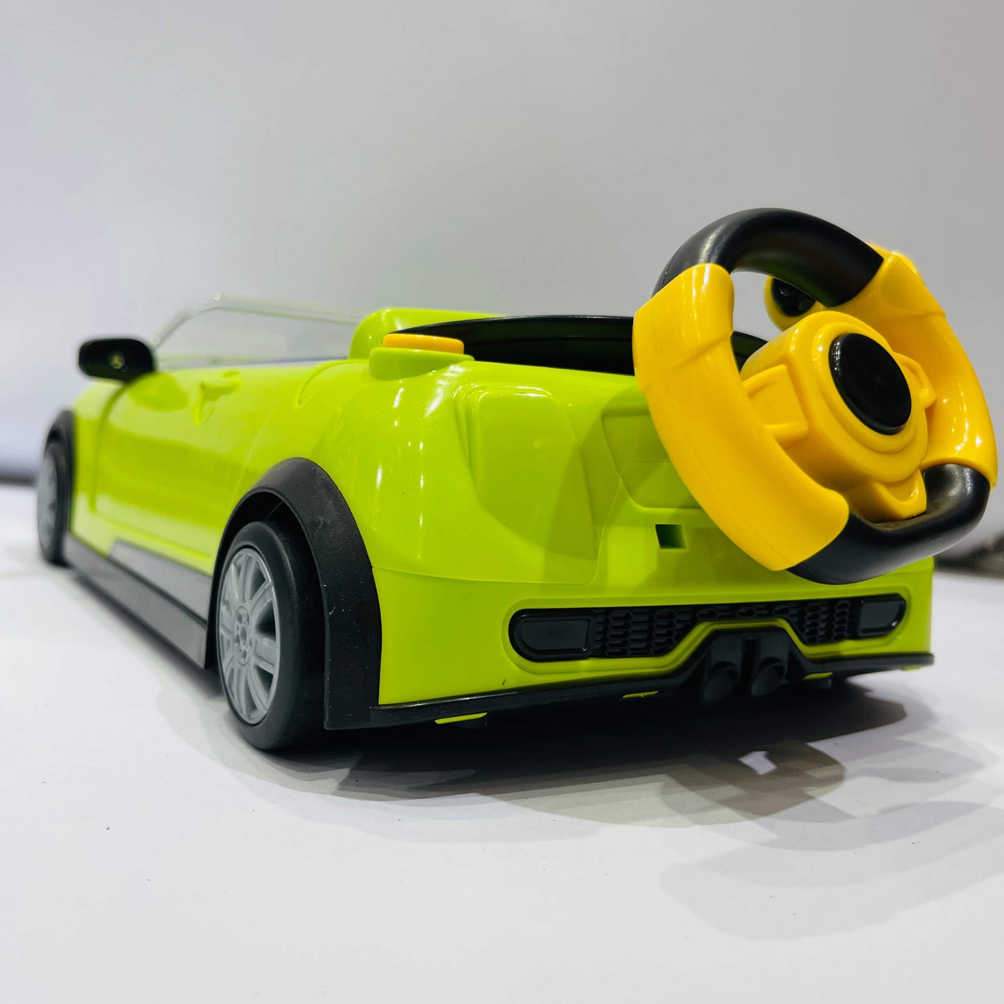 Toy car with a steering wheel attachment on a white background