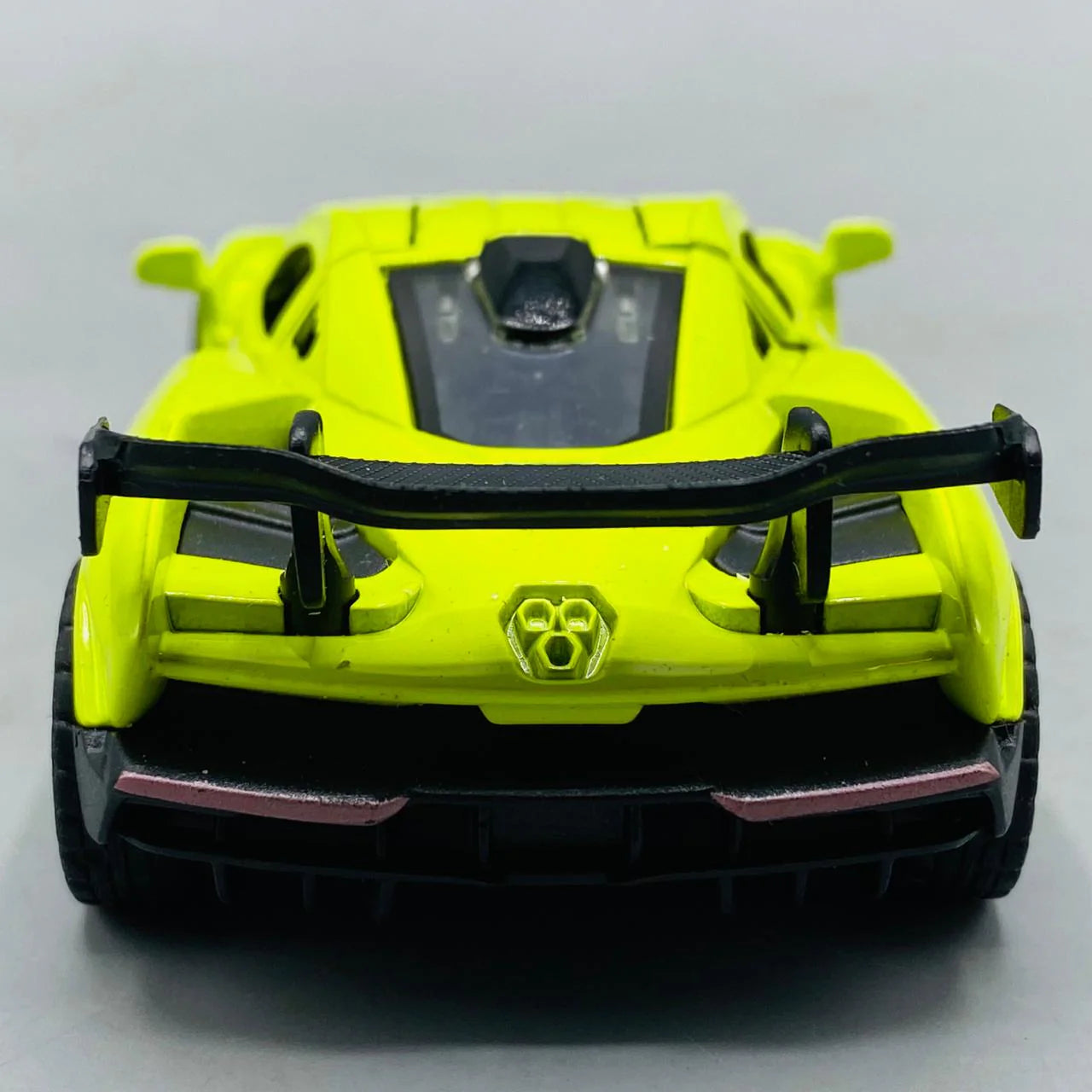 Yellow toy car with black accents on a light gray background