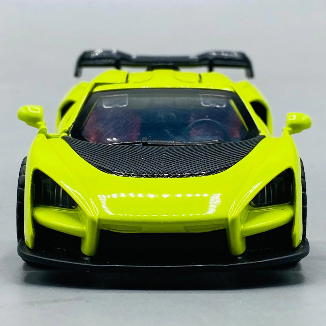 Yellow toy car with black accents on a gray background