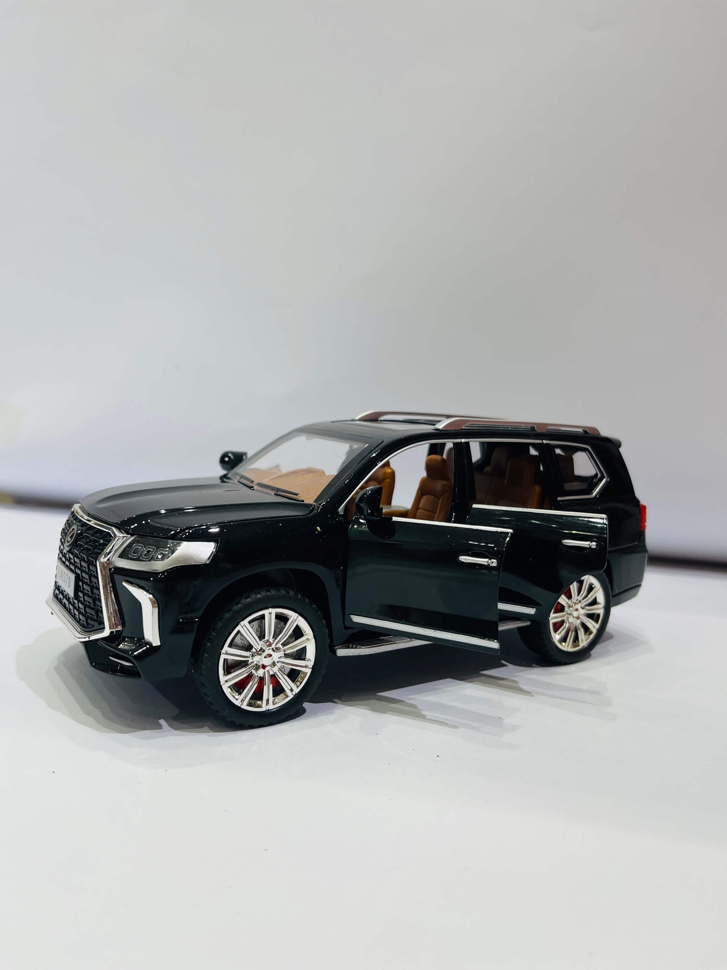  A black diecast model of a Lexus LX570 SUV, viewed from the front three-quarter angle on a white background.
