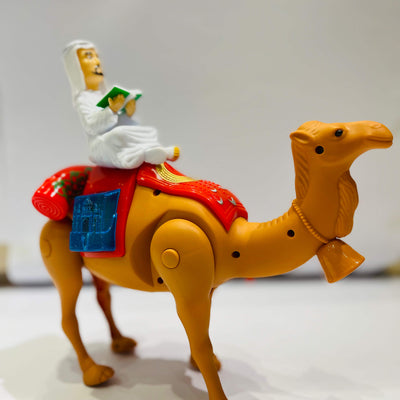 Toy figure of a person riding a camel on a plain background