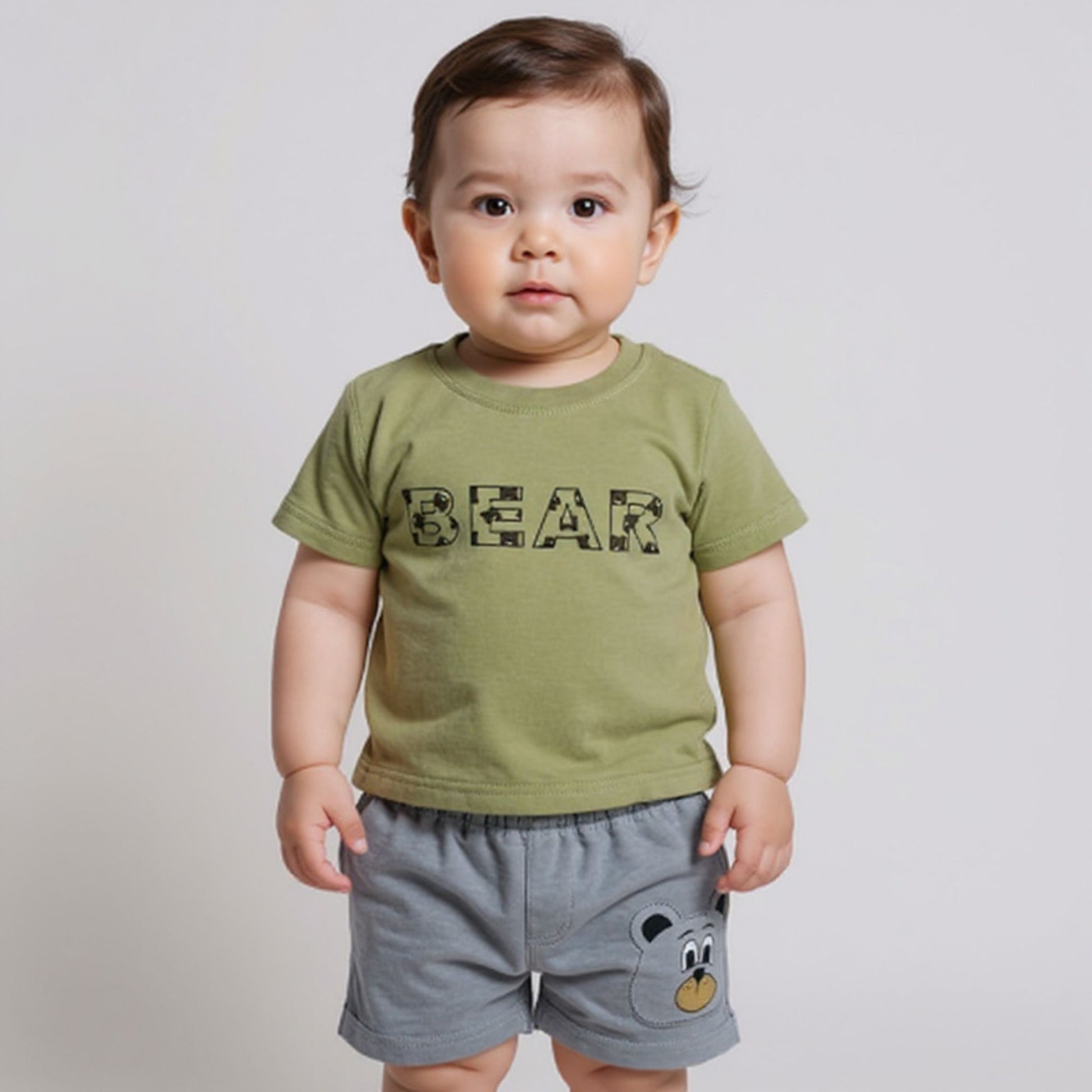Child wearing a green t-shirt with 'BEAR' printed on it and gray shorts with a bear design.