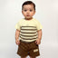 Child wearing a striped shirt and brown shorts with a visible brand logo on a plain background