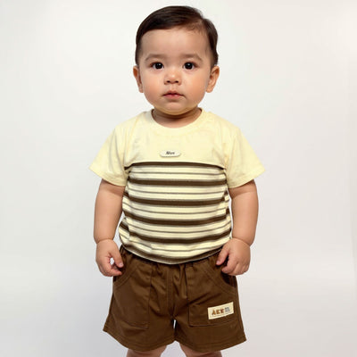 Child wearing a striped shirt and brown shorts with a visible brand logo on a plain background