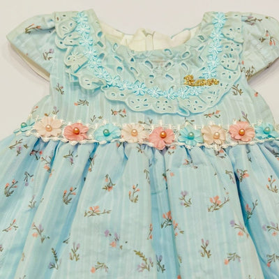 Light blue dress with floral details and embroidery.