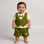 A smiling baby boy wearing a green vest and shorts set with a bow tie.