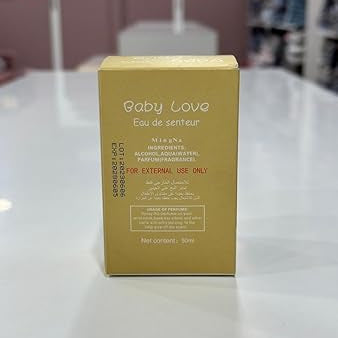 Gold box labeled 'Baby Love' on a white surface with a blurred background