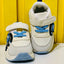 White sneakers with blue laces and soles on a yellow background