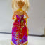 Doll with a colorful dress on a plain background