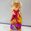 Toy doll with a colorful dress and pink guitar on a white background