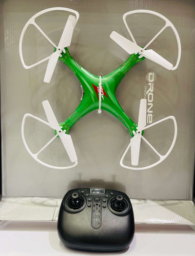 Green drone with white propellers and a black remote control on a reflective surface.