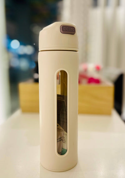 Beige travel mug with a window on a blurred background