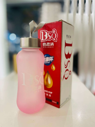 Pink tumbler with a straw next to a red box labeled 'BSQ' on a blurred background