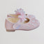 Pink children's shoes with floral design on a light gray background