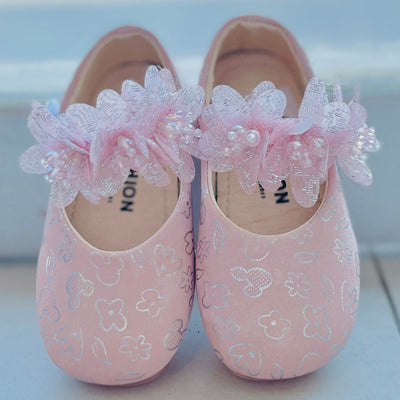 Pink children's shoes with floral decorations on a white background