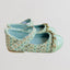 Light blue textured shoe with a strap on a light gray background