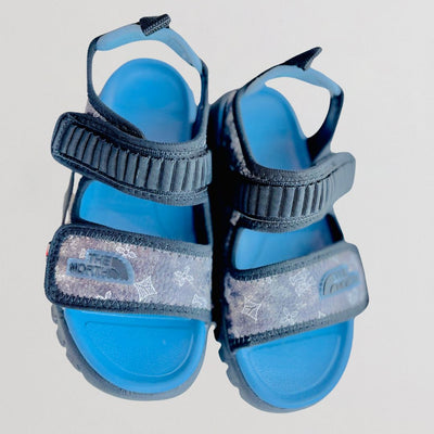 Blue sandals with gray straps on a light gray background