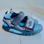 Blue and gray sandals with a visible brand logo on a white background