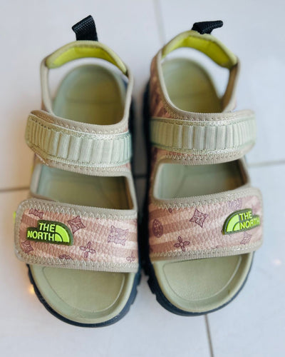 Pair of children's sandals with The North Face logo on a white background
