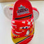 Red children's sandals with cartoon character design on a white surface.
