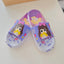 Pair of children's slippers with cartoon character design on a light background
