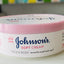 Johnson's Soft Cream jar on a white surface with a colorful background