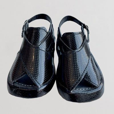 Pair of black open-toe shoes with a textured surface on a light gray background