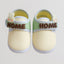 Pair of baby shoes with 'HOME' label and bunny decorations on a light gray background