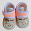 Pair of baby shoes with 'lucky bear' design on a light background