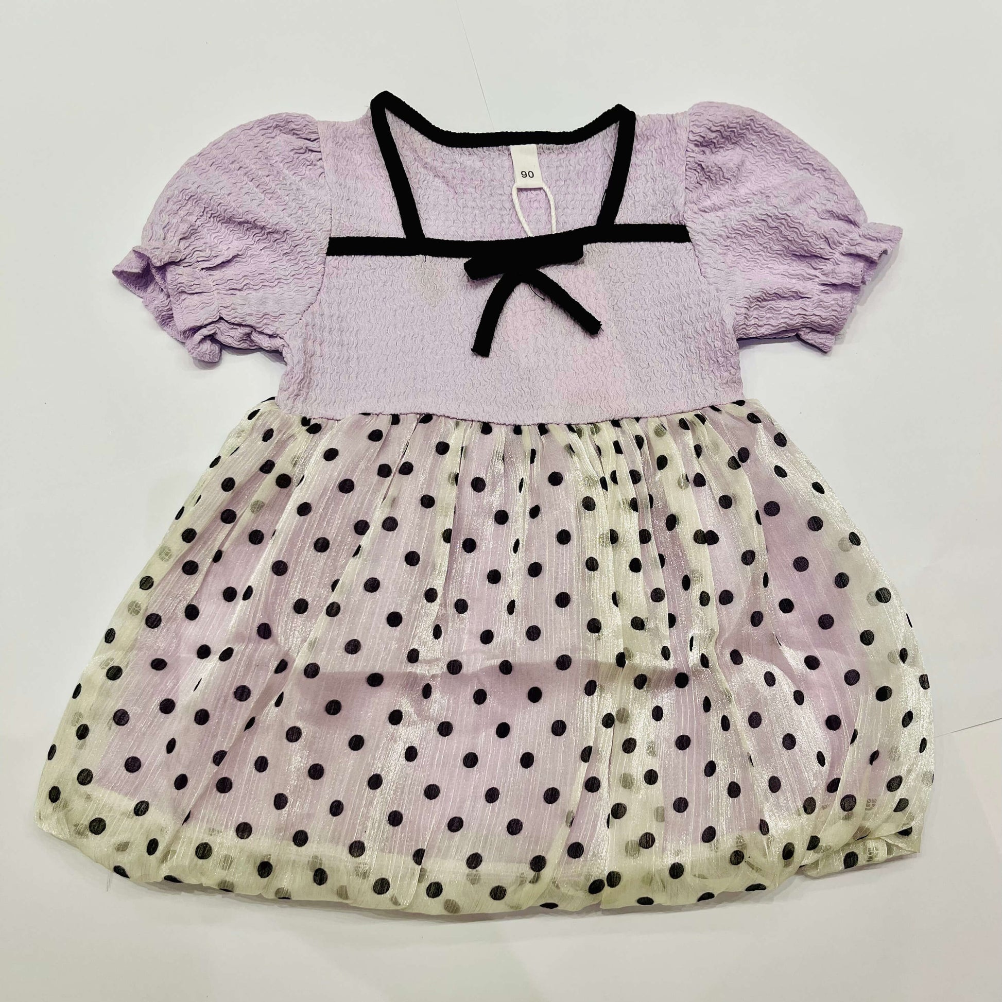 Lavender dress with black polka dots on a white background