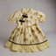Yellow dress with leaf pattern and black accents 