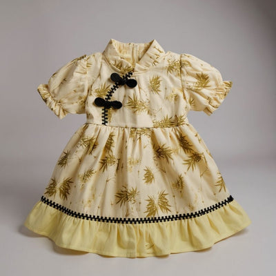 Yellow dress with leaf pattern and black accents 