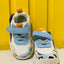 Children's sneakers with blue straps on a yellow background