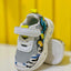 Gray children's shoe with colorful designs on a yellow background