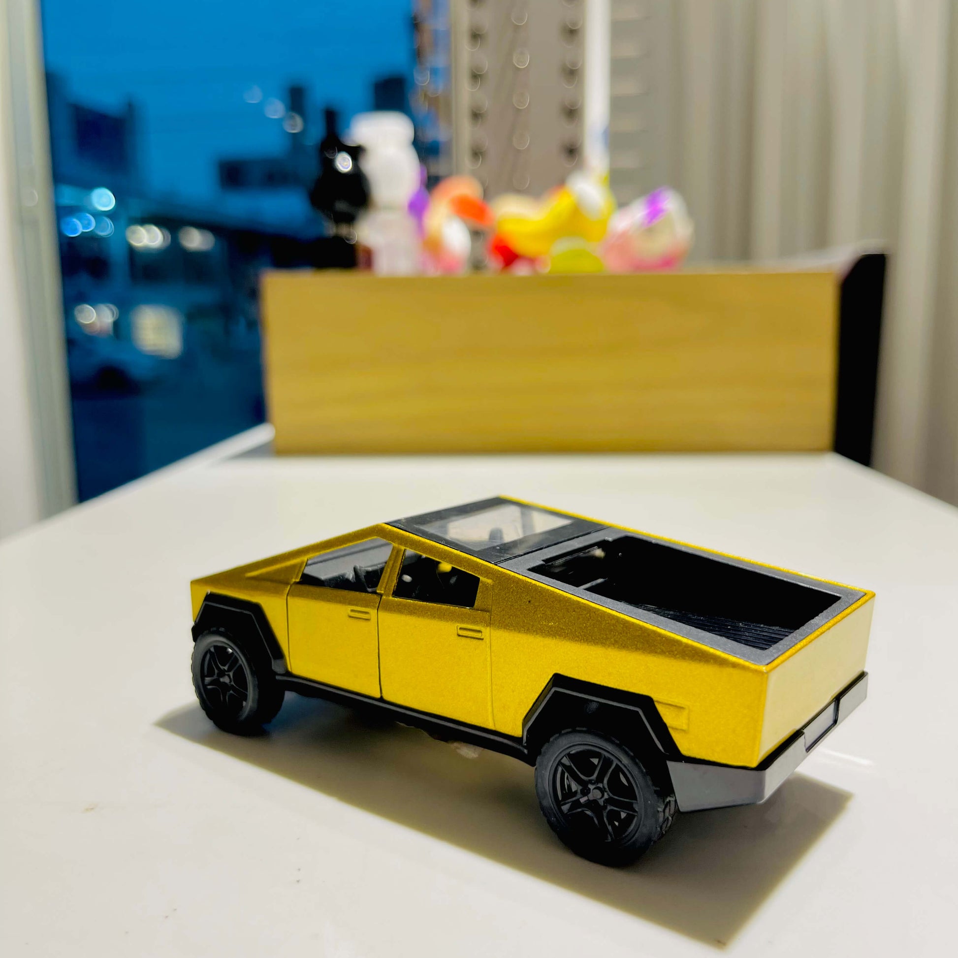 Yellow toy car on a white surface with a blurred background