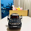 Toy Mercedes-Benz G-Class on a table with a cityscape background