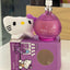 Purple 'Baby Love' perfume bottle with Hello Kitty plush toy on a matching box.