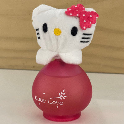 Hello Kitty plush toy on top of a red bottle labeled 'Baby Love' with a wooden background.