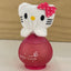 Hello Kitty-themed perfume bottle with a pink bow on a wooden surface