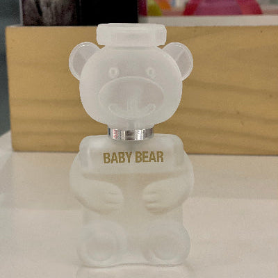 Frosted glass bear-shaped bottle with 'Baby Bear' text on a reflective surface.