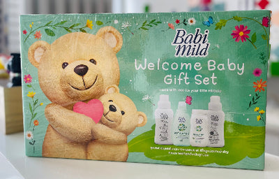 Babi Mild welcome baby gift set packaging with teddy bears and bottles on a green background