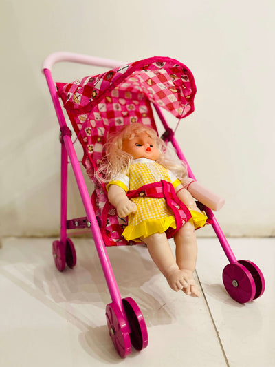 Toy doll in a pink stroller with a checkered canopy on a light background