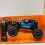 Blue remote control monster truck on an orange stand with a white background