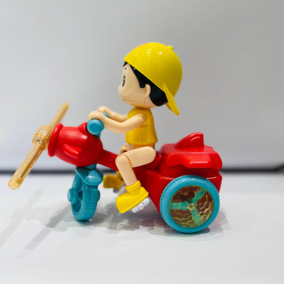 Toy figure of a child on a red motorcycle with blue wheels against a white background