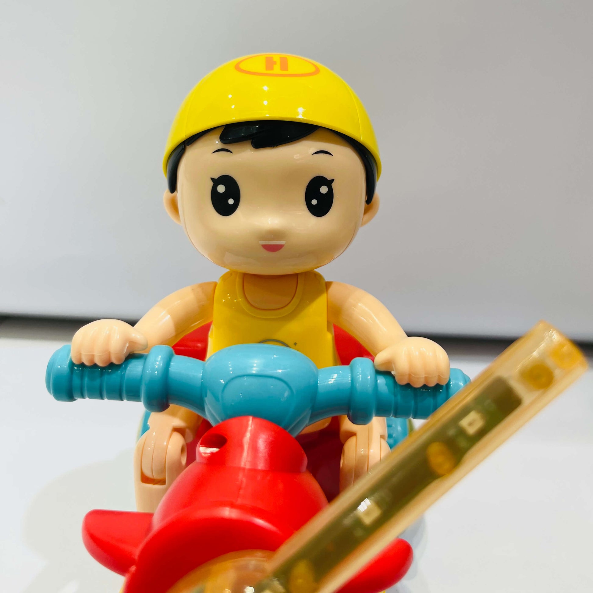 Toy figure of a child on a toy motorcycle with a white background